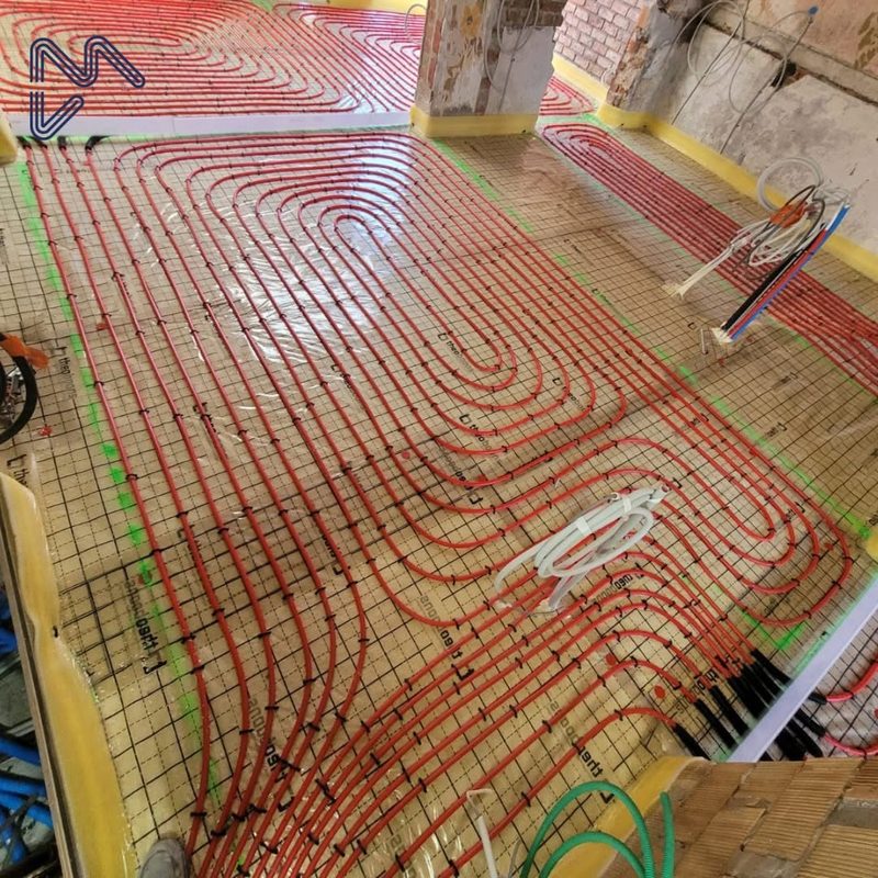 Rode vloerverwarmingsleidingen op isolatiefolie in een renovatiewoning