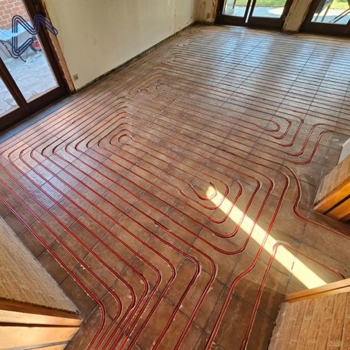 Renovatiewoning met rode vloerverwarmingsleidingen ingefreesd in de bestaande tegelvloer